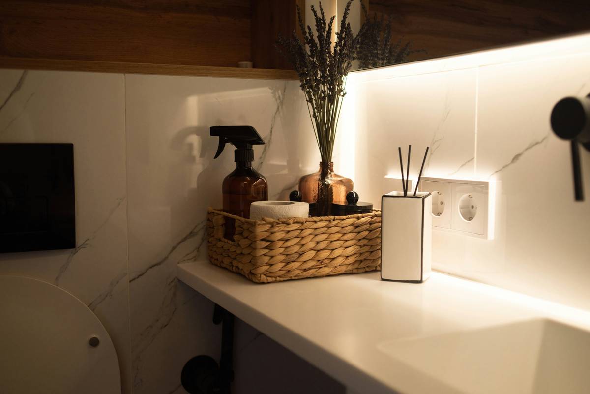 bath essentials list featuring biodegradable toilet paper, bamboo toothbrush, and refillable soap bottles on a wooden bathroom shelf